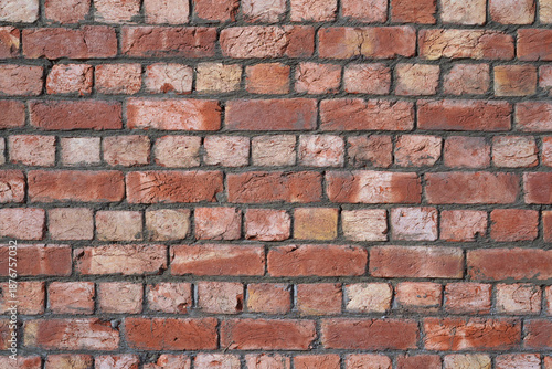 Brick wall. Industrial textured background. Red hand-molded bricks, with visible layers of clay and a rough texture, freshly laid in cement mortar. Careful masonry of uneven bricks.