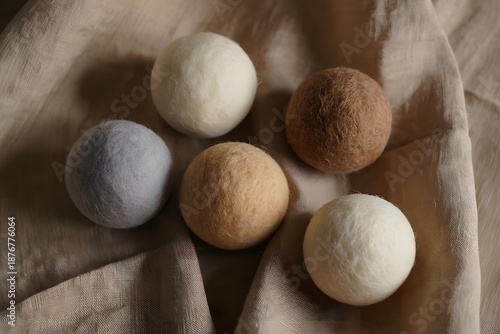 Wool dryer balls on beige fabric, eco-friendly laundry essentials
