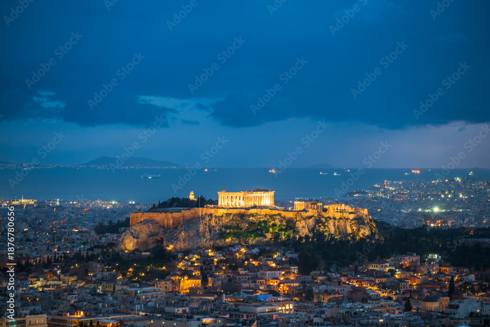 Naklejka premium Illuminated Acropolis of Athens at dusk with clouds