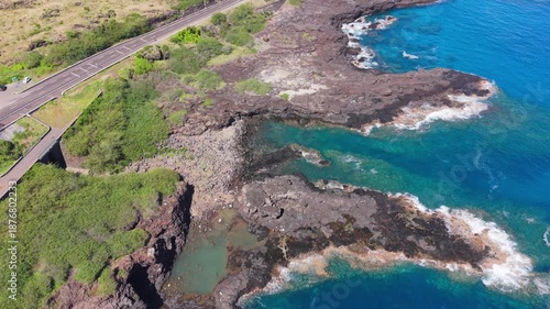 Aerial drone footage moving forward along a coastal road by the ocean, Reunion Island