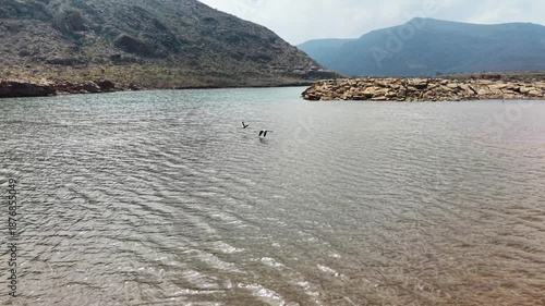 Serene Lake with Rocky Hills and Cloudy Sky