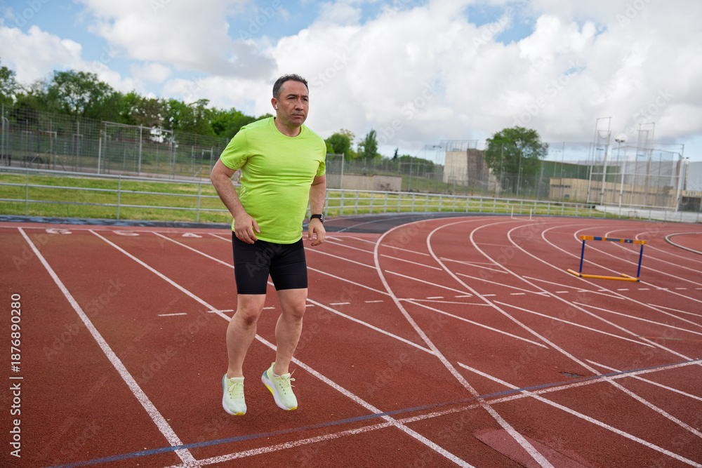 Fototapeta premium Man running on athletics track for fitness training
