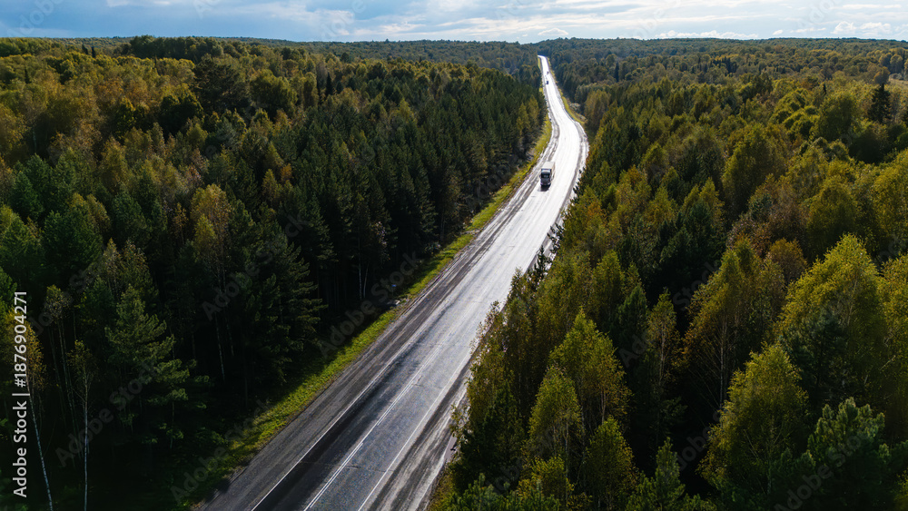 Obraz premium a truck driving on the highway at sunset, drone view