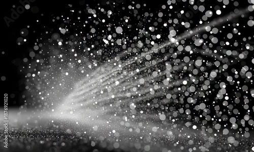 A dynamic burst of shimmering white particles and bokeh lights radiates outwards against a dark black background.