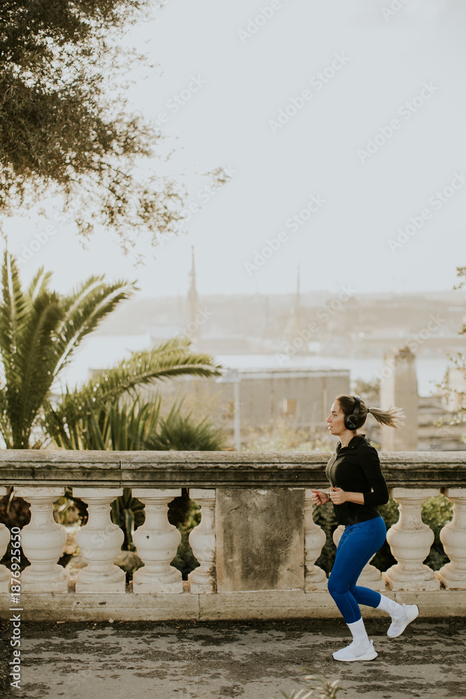 Fototapeta premium Woman jogging by the coast in Malta while enjoying the view during the day