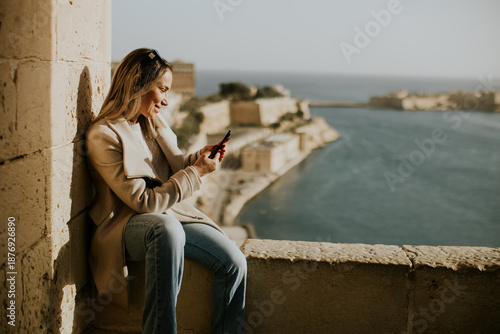 Woman sitting on a wall in ...