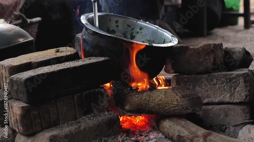 COOKING CHICKEN IN A RURAL KITCHEN IN UGANDA, AFRICA, OVER A WOOD FIRE, IN A NATURAL SETTING