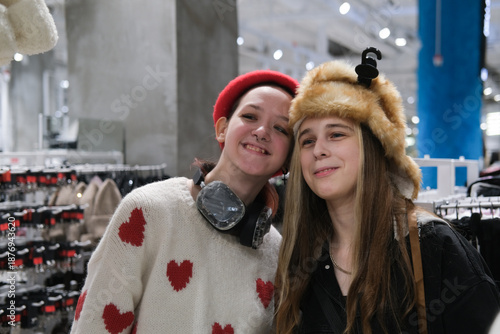 Two teenage friends are shopping for warm winter clothes.