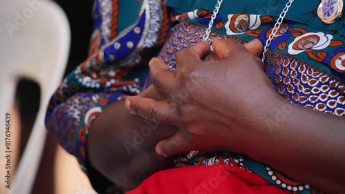 Hands joined in prayer in Uganda, Africa, among the colors

