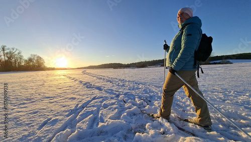 Mature woman skiing on trail in winter cold weather. Cross-country skier in snowy National park Sumava, Czech Republic.