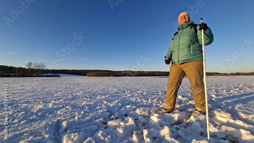 Mature woman skiing on trail in winter cold weather. Cross-country skier in snowy National park Sumava, Czech Republic.