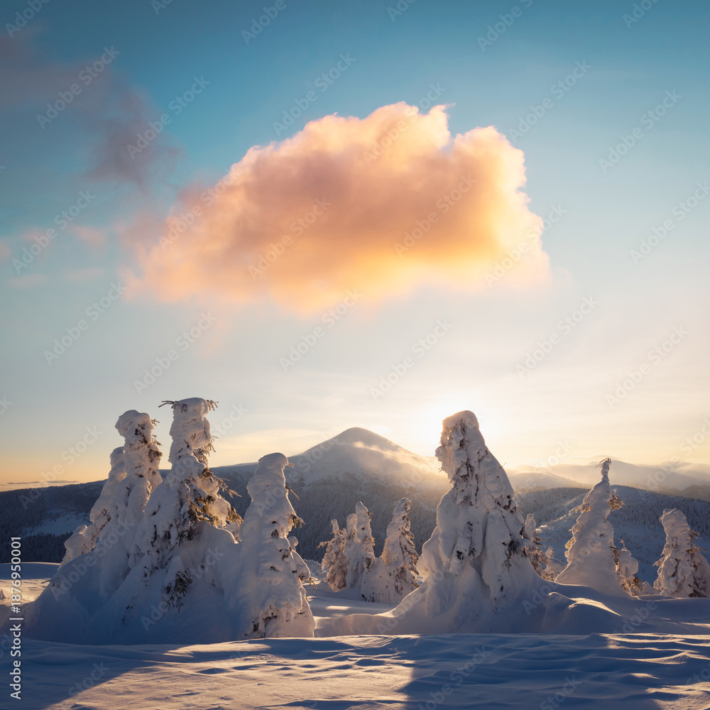 Obraz premium Winter mountains at sunrise with snowy peaks and warm colorful clouds. Scenic snowy landscape with bright morning light