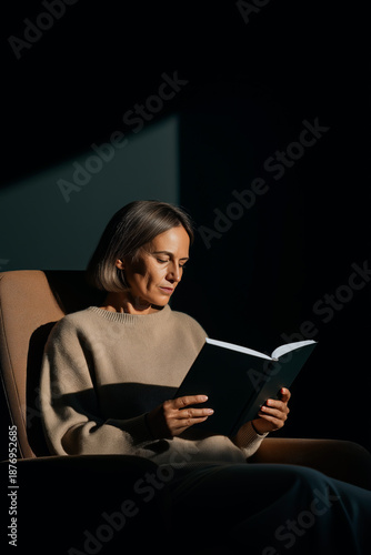 Woman Reading Book in Minimal Dark Interior – Calm Lifestyle Concept
