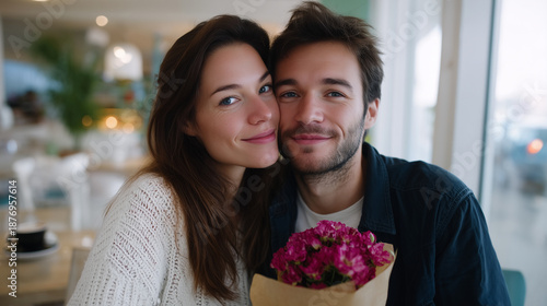 a young couple relaxing in a bright cafe, sharing an affectionate moment with a small bouquet of flowers