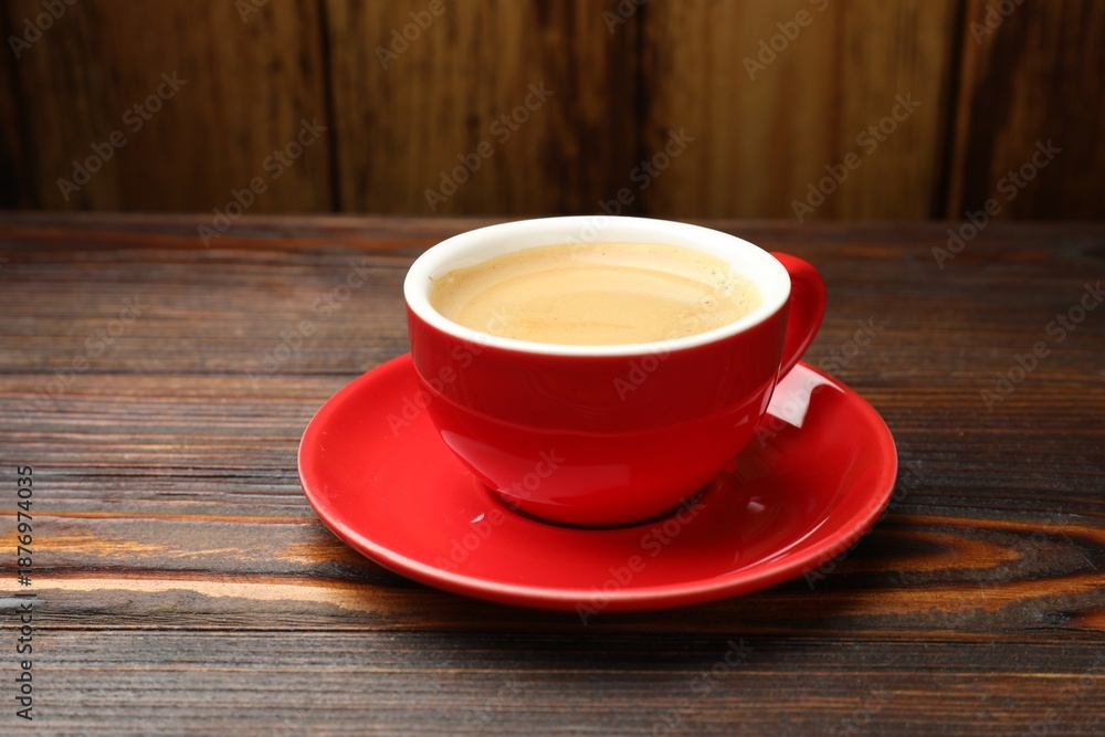 Obraz premium Cup with aromatic coffee on wooden table, closeup