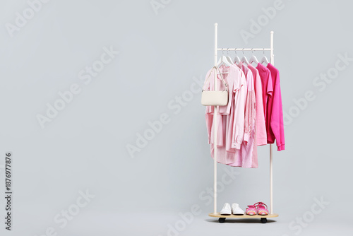 Wallpaper Mural Different clothes hanging on rack, bag and shoes against light grey background, space for text Torontodigital.ca