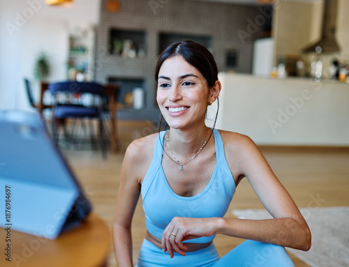 Free Download Portrait of a fit latina  girl young woman exercising practicing yoga or fitness watching online instructions tutorial on laptop at home - GFXLoad
