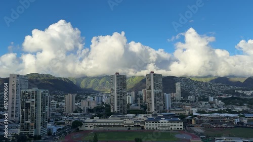 Cumulus clouds. Koʻolau Range is the dormant fragmented remnant of the eastern or windward shield volcano. ‘Iolani School. Waikiki, Honolulu, Oahu, Hawaii. 
