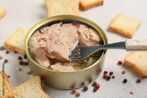 Fotografija Tin can with tasty cod liver, crackers and peppercorns on light background, clos