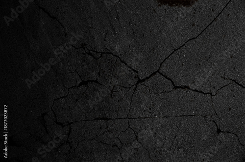 Photos Primer plano de asfalto o concreto oscuro con grietas irregulares que forman una superficie fracturada y texturizada