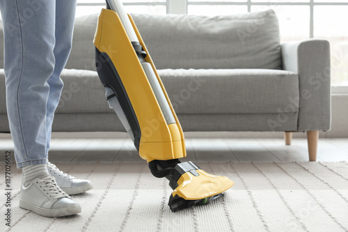 Young woman hoovering carpe...