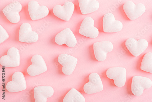 Pink sugar candies in a shape of hearts on pink background. Creative holiday concept of love. Valentine's day