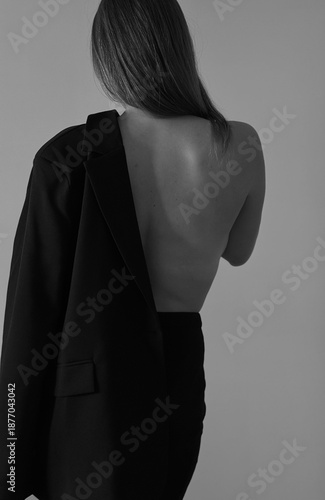 Boudoir photo shoot of a girl. Black and white photo. Naked neck, shoulders and back of a young girl.
