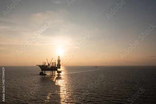 Aerial view of offshore jack up rig in a shipyard during sunset for oil and gas exploration and production.