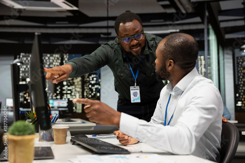 Black company advisors doing teamwork at night to meet deadlines, completing monthly reports and reviewing KPI numbers for business productivity. Tasks in strategy room after hours.