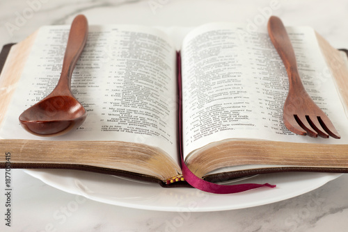 Holy bible with wooden spoon and fork. Fasting and spiritual food, Christian biblical concept.