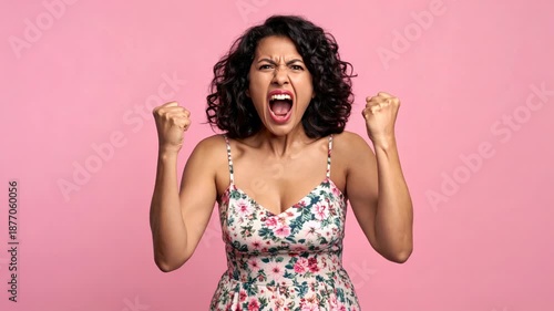 Angry Woman Shouting with Fists Raised Against Pink Background