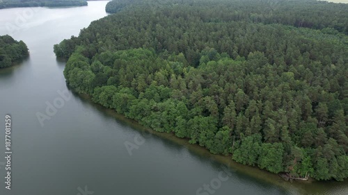 Forested Area With River Running Through it. Water is Calm and Clear. Trees Are Lush Sky is Cloudy. Dramatic Aerial View of Big Lake and Green Forest. Epic Amazing Nature Landscape Nature Reserve.