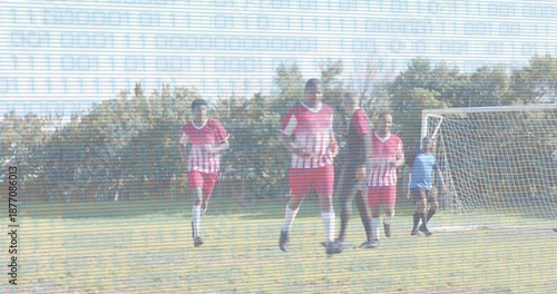 Running players in red-white jerseys defending near goal net on grass pitch, scanlines overlaying