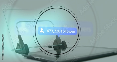 Displaying 473,226 Followers bubble over tablet on glossy tabletop with clamp magnifier glass panel
