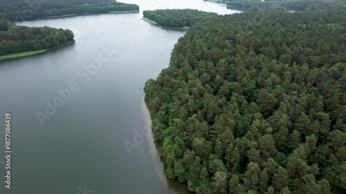 Forested Area With River Running Through it. Water is Calm and Clear. Trees Are Lush Sky is Cloudy. Dramatic Aerial View of Big Lake and Green Forest. Epic Amazing Nature Landscape Nature Reserve.