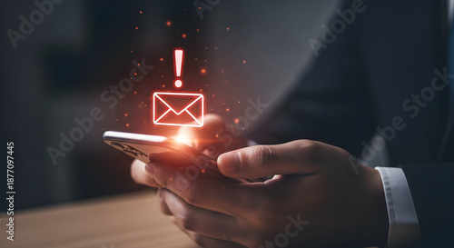 Person holding smartphone with glowing email notification and exclamation mark indicating important message received