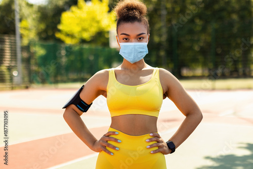 Wallpaper Mural Sport And Quarantine Concept. Portrait of athletic fit black woman wearing surgical medical face mask posing on basketball playground, exercising outdoors during covid pandemic. Protection, New Rules Torontodigital.ca