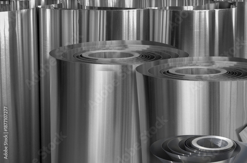 a bunch of rolls of aluminum metal. thin metal. standing side by side.