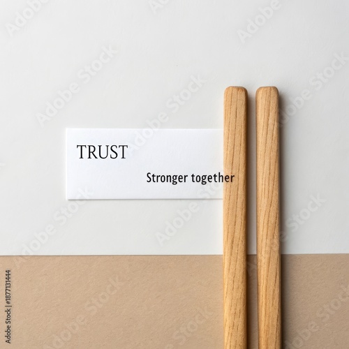 Wooden sticks and a card with the words Trust and Stronger together conveying a message of unity and collaboration