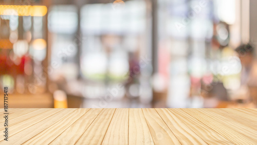 Empty wooden table top with blurred coffee shop interior background for product display mockup © Kwangmoozaa
