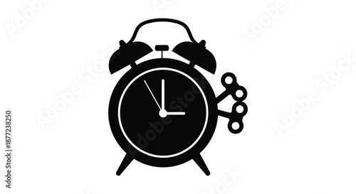 A classic black alarm clock with visible hands and winding key a striking silhouette