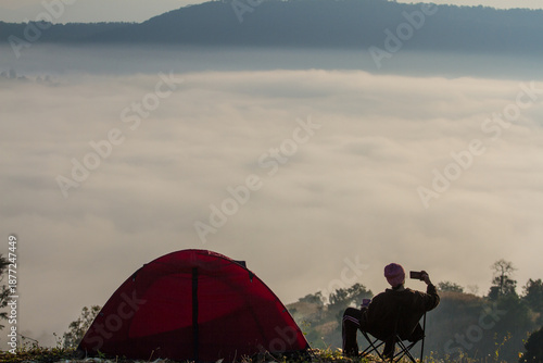 person camping in the mountains with view sea of mist in the morning