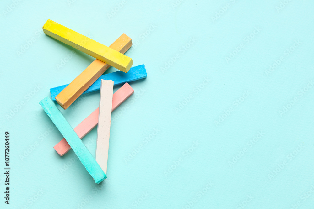 Obraz premium Pieces of colorful chalks on blue background