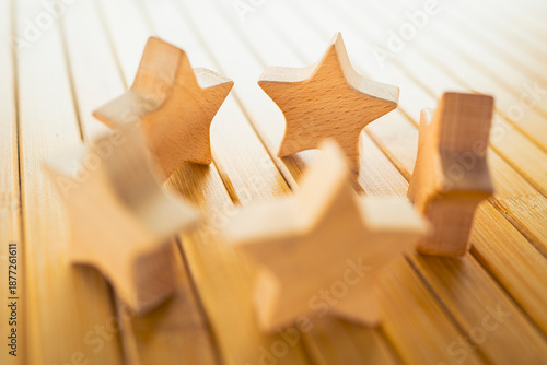 Wooden star figures arranged on table representing customer rating, product review, service quality evaluation, satisfaction measurement, business feedback and brand reputation concept.