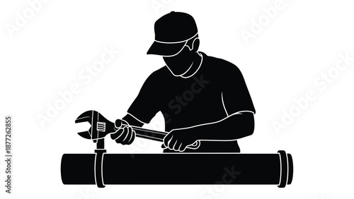 Silhouette of a plumber wearing a cap working diligently to fix a large pipe connection using an adjustable wrench in a focused industrial setting for repairs.