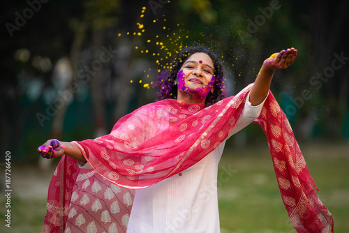 young indian woman playing colors on traditional festival holi