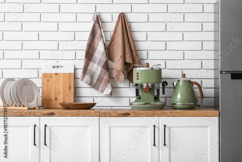 Modern coffee machine, electric kettle, clean plates and napkins on counter in kitchen © Pixel-Shot