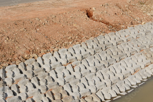 Retaining slope wall to protect pressed soil surface and prevent landslip made from concrete blocks.