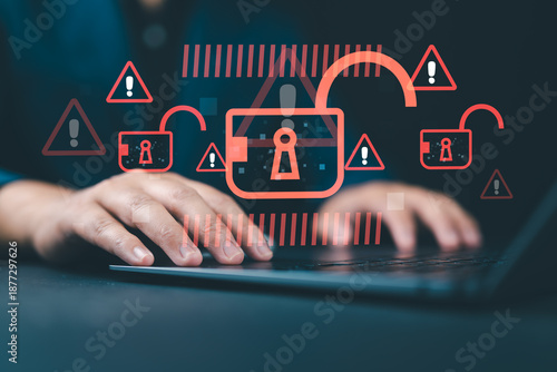 Photography Hacking and system intrusion concept with a hacker using a laptop to steal data, symbolizing unauthorized access, account takeover, and security breaches with unlocked padlock icons