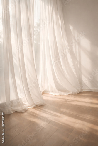 White sheer curtains gently blowing in the breeze with sunlight casting shadows on a wooden floor, creating a serene and airy atmosphere.